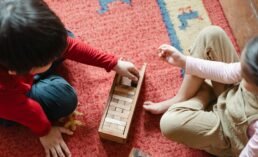 crop cute kids playing jenga on floor at home