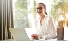 laughing businesswoman working in office with laptop