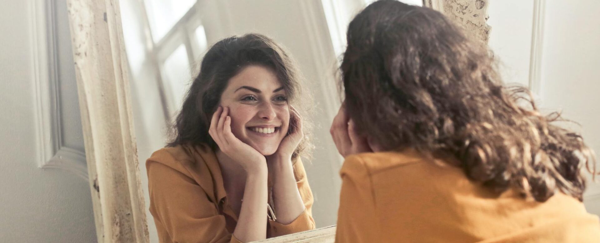 photo of woman looking at the mirror