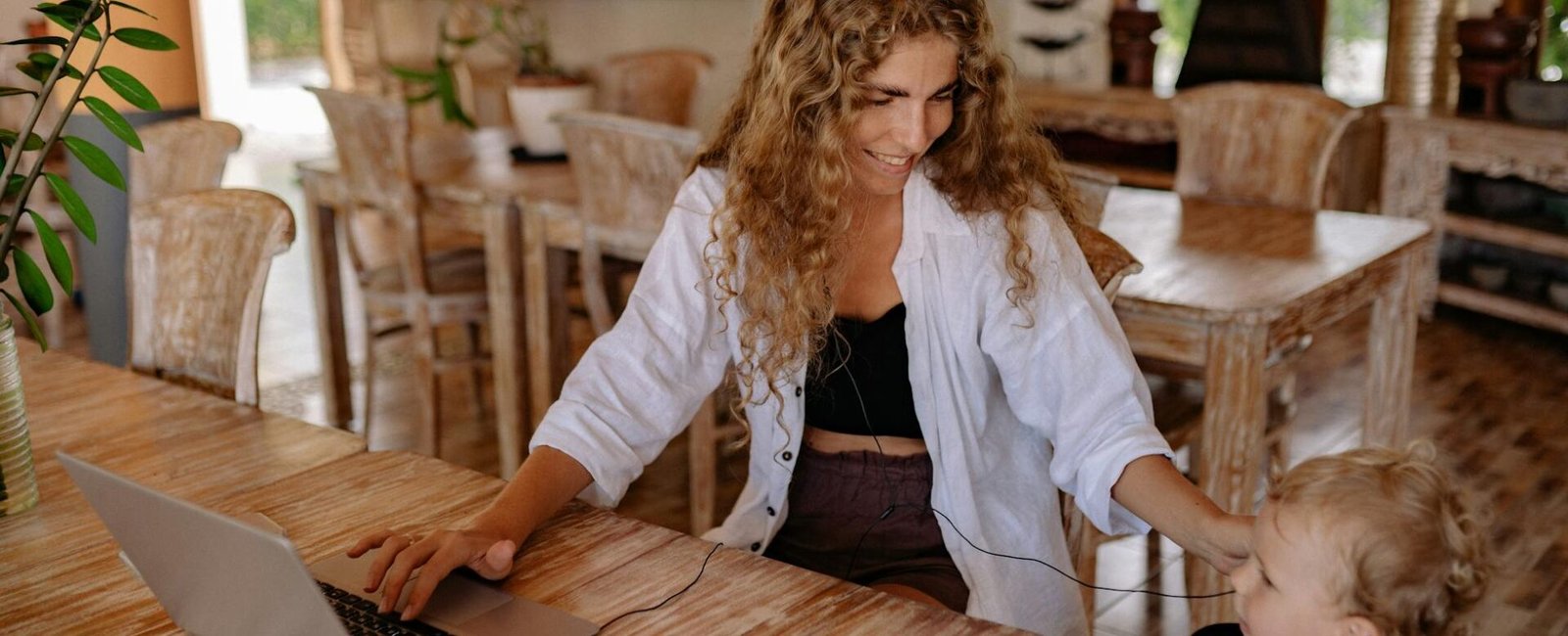 photo of woman smiling while sitting by the table with her child